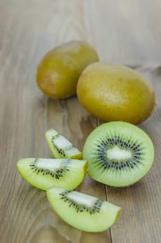 delicious whole kiwi fruit and sliced on wooden background