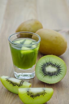 glass of kiwi juice with fresh fruits on wooden table