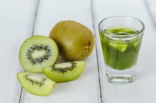 glass of kiwi juice with fresh fruits on wooden table