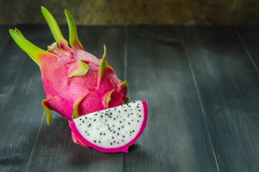 Ripe Dragon fruit or Pitaya with slice on wooden background , still life