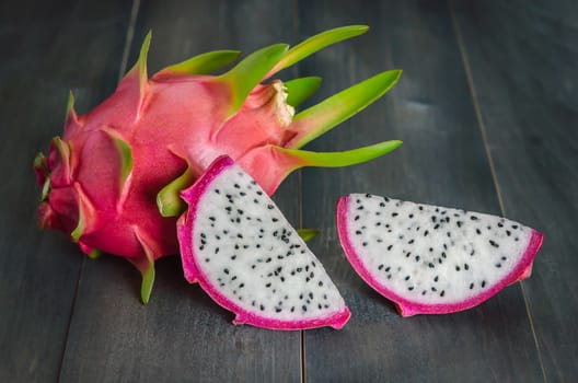 Ripe Dragon fruit or Pitaya with slice on wooden background , still life