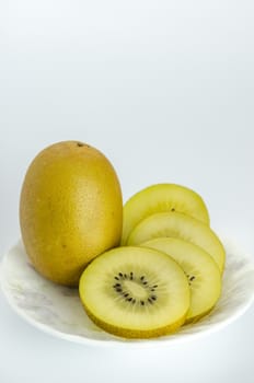 golden kiwi fruit and sliced on dish over white background