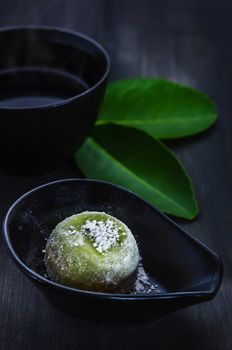 Green Daifuku Mochi Japanese dessert on dish served with  hot tea , still life