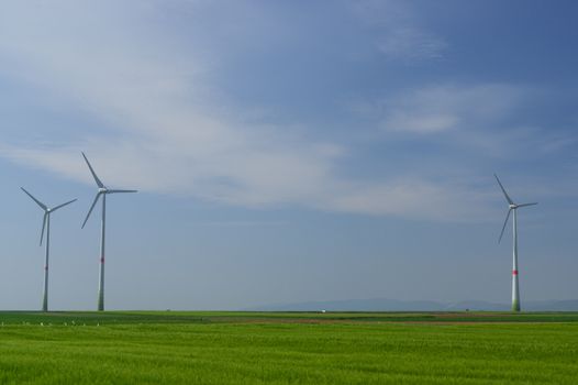 meadow with Wind power turbines generating electricity