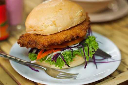 vegetarian burger made from vegetables and breadcrumbs, stacked with onion rings
