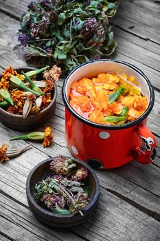 iron mug with herbal decoctions of clover and marigolds