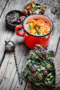iron mug with herbal decoctions of clover and marigolds