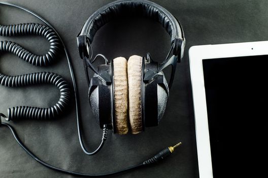 blank notebook in top view with music concept 
Black background headphones