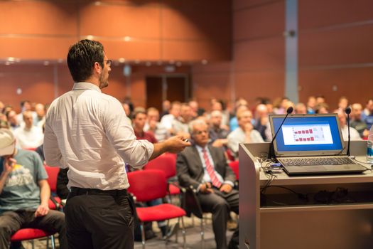 Speaker giving a talk on corporate Business Conference. Audience at the conference hall. Business and Entrepreneurship event.