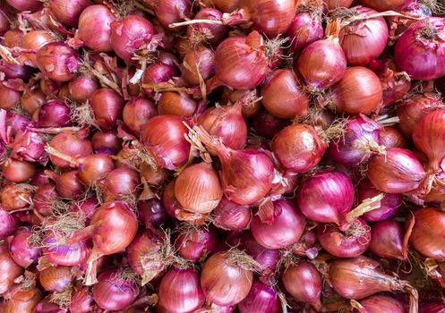 Heap of red onions on market place