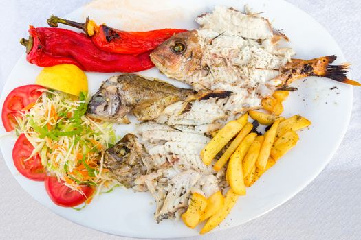 Mediterranean menu fish fries and vegetables on plate