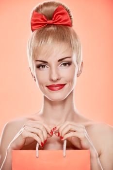 Beauty fashion portrait loving woman smiling with shopping bag. Confidence sensual attractive pretty nude blonde sexy girl, Pinup hairstyle, red bow. Unusual playful. Romantic on pink, sale, discount