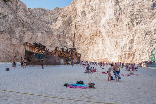 Zakynthos, Greece - August 27, 2015: Tourists at the Navagio Beach and view of Shipwreck on Zakynthos Island. Famous Navagio Beach is the most popular tourist attraction on the island.