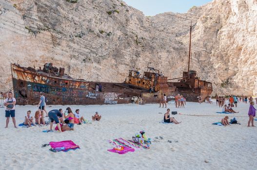 Zakynthos, Greece - August 27, 2015: Tourists at the Navagio Beach and view of Shipwreck on Zakynthos Island. Famous Navagio Beach is the most popular tourist attraction on the island.