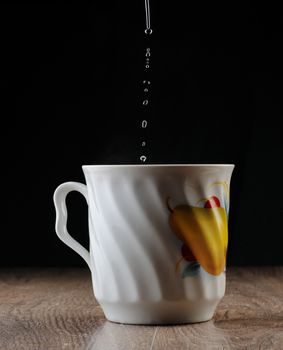 Water Drops falling in big tea cup 