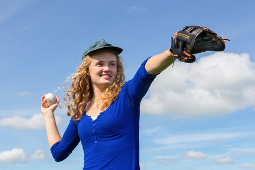 Young caucasian woman playing baseball with cap glove and ball
