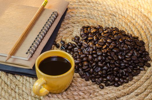 Cup of coffee with  notebook on a jute rope.