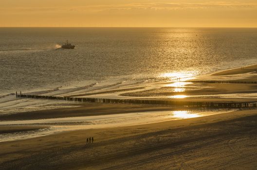 Walking on the sandy beach of Zoutelande at sunset
