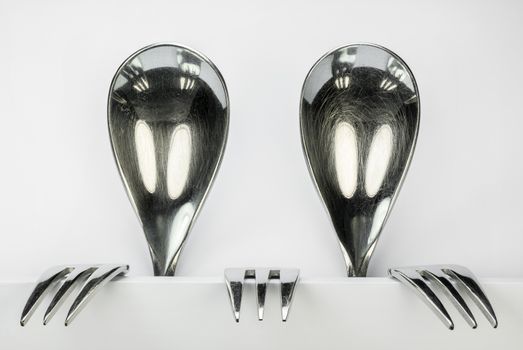 Metal spoons and three forks formed into two conceptual fantasy figures
