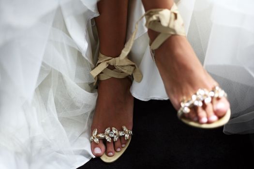 Wedding shoes on barefooted legs of the bride