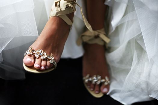 Wedding shoes on barefooted legs of the bride