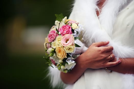 The bride holds a wedding bouquet