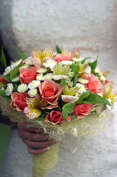 Wedding bouquet from roses on a dress background