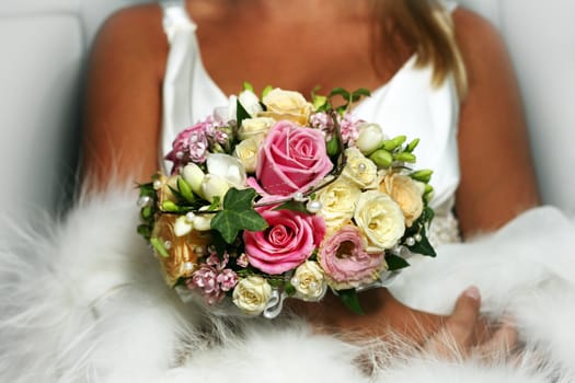 The bride holds a wedding bouquet