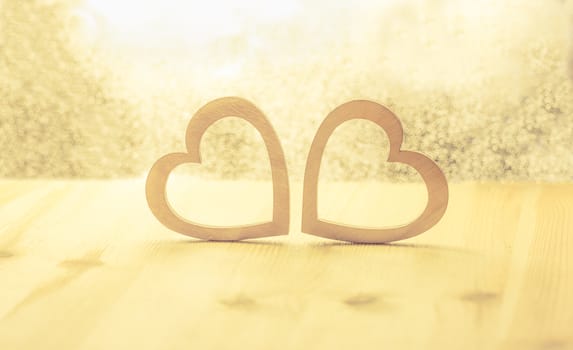 Romantic scenery with two hearts made from wood against a bright background