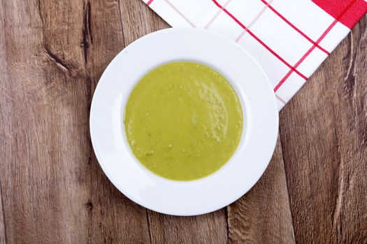 Vegetable split pea soup on a brown wooden background