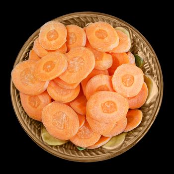 Sliced carrots in a bowl isolated on black background