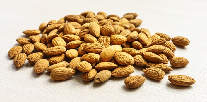 Pile Of Tasty Almonds Nuts On White Background. Inexpensive Real Food Snack For Sport And School