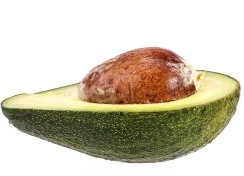 Half  avocado with stone isolated on white background, close up