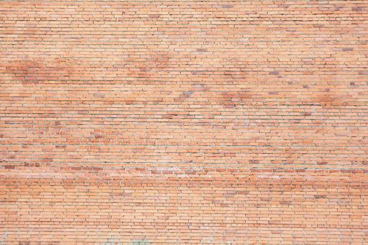 Large uneven wall of red different shades bricks