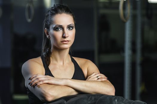 Concept: power, strength, healthy lifestyle, sport. Powerful attractive muscular woman CrossFit trainer doing giant tire workout at the gym