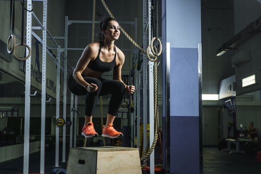 Concept: power, strength, healthy lifestyle, sport. Powerful attractive muscular woman CrossFit trainer do jumps during workout at the gym