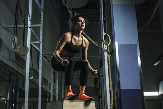 Concept: power, strength, healthy lifestyle, sport. Powerful attractive muscular woman CrossFit trainer do jumps during workout at the gym