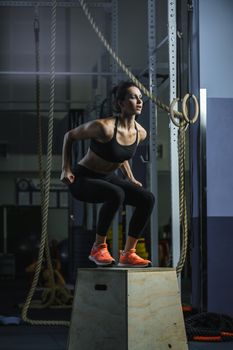 Concept: power, strength, healthy lifestyle, sport. Powerful attractive muscular woman CrossFit trainer do jumps during workout at the gym