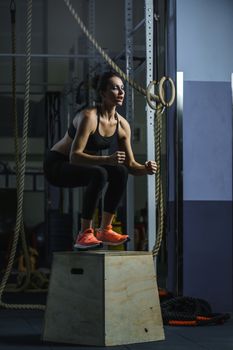 Concept: power, strength, healthy lifestyle, sport. Powerful attractive muscular woman CrossFit trainer do jumps during workout at the gym