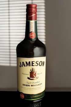 Jameson is a blended Irish whiskey produced by the Irish Distillers subsidiary of Pernod Ricard. A bottle Jameson in the room, illuminated by the light from the window