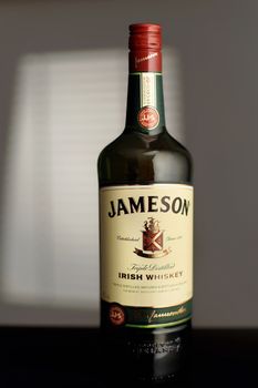 Jameson is a blended Irish whiskey produced by the Irish Distillers subsidiary of Pernod Ricard. A bottle Jameson in the room, illuminated by the light from the window