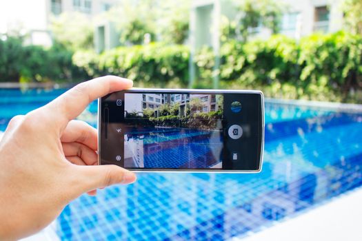 photo shooting on smartphone at swimming pool on holiday time