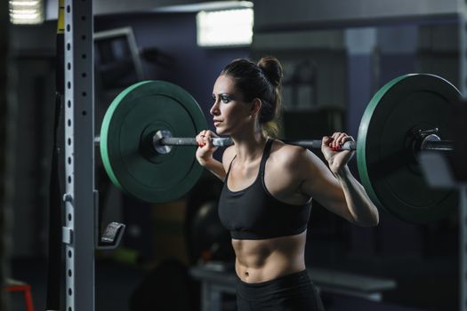 Concept: power, strength, healthy lifestyle, sport. Powerful attractive muscular woman CrossFit trainer do workout with barbell at the gym