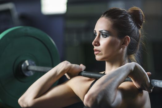 Concept: power, strength, healthy lifestyle, sport. Powerful attractive muscular woman CrossFit trainer do workout with barbell at the gym