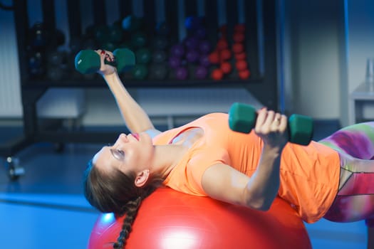 Concept: power, strength, healthy lifestyle, sport. Powerful attractive muscular woman fitness trainer working out at the gym