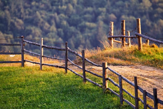 September rural scene in Carpathian mountains. Authentic village and fence