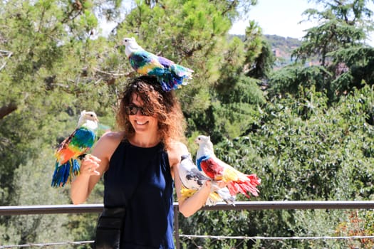 Amazingly beautiful birds in the Park Guell on the beautiful young girl.