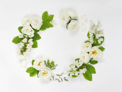 Decorative composition in retro style consisting of white wild rose and white locust flowers with green leaves on white background. Top view, flat lay
