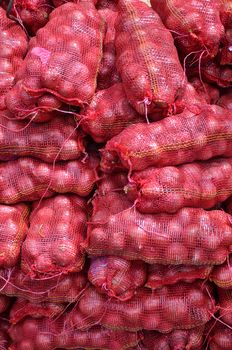 Sacs containing Large onion stacked for sale at Local Market at Little India, Singapore