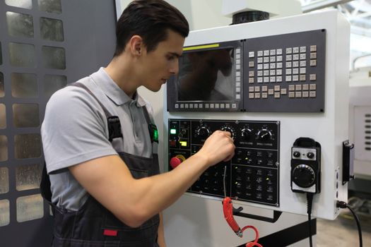 Worker in electrical switchgear room of CNC plant